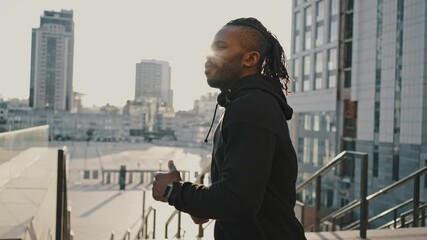 Close up portrait of active sporty man enjoying morning run practice at urban area in city, cinematic shot, slow motion