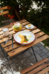 breakfast on the terrace of a local cafe sea buckthorn tea and fried banana dessert with fruit and caramel