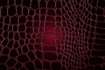 Dark crocodile skin texture in red color. Red reptile leather imitation texture to background.