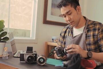 A man cleaning camera lens, Asian man fixing camera, Professional photographing equipment care.
