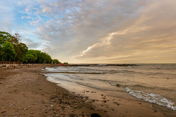 Toronto Beaches sunset with waves breaking on the sand, seen from Kew Beach in Toronto's east end.