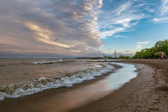 Toronto Beaches sunset with waves breaking on the sand, seen from Kew Beach in Toronto's east end.