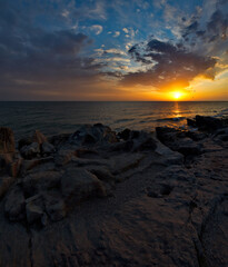 Russia. Dagestan. Dawn on the rocky shore of the Caspian Sea near the city embankment of Makhachkala.