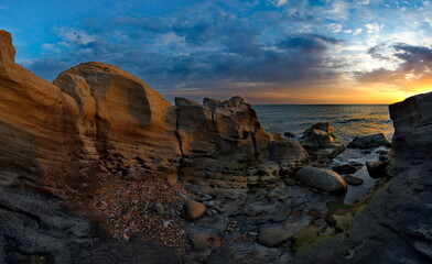 Russia. Dagestan. Dawn on the rocky shore of the Caspian Sea near the city embankment of Makhachkala.