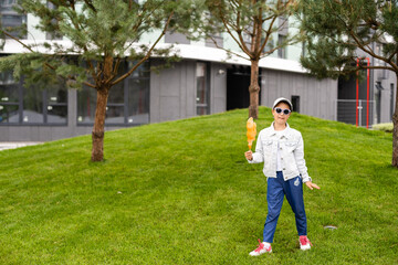 Adorable and pretty little girl eating sweet cotton candy. Happy child, kid eating candy-floss with emotions in the park at summer or spring.