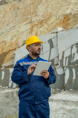 Middle aged builder using tablet at building place