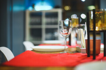 Empty table with red tablecloth served for reception of guests for dinner