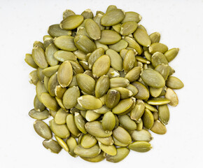 pile of hulled pumpkin seeds close up on gray