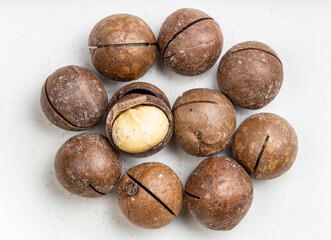 several sawn and shelled macadamia nuts on gray