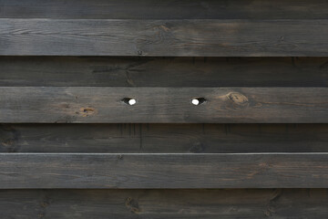 Wooden fence with two holes in shape eyes. Covert surveillance concept.