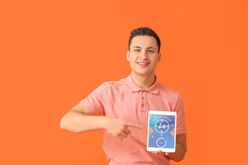 Young man and tablet computer with open page of delivery service application on color background