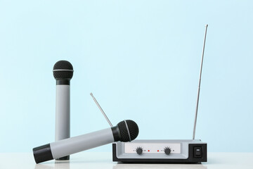 Modern microphones and audio system on color background