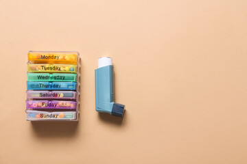 Inhaler and pills on color background