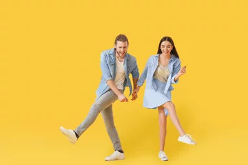 Fotobehang Happy young couple dancing on color background © Pixel-Shot