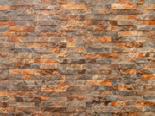 Brick wall made of natural stone of different colors. Marble decorative texture.