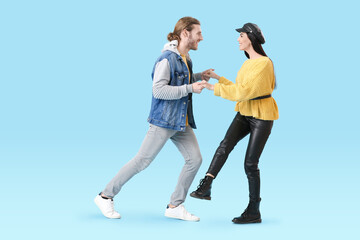Obraz premium Happy young couple dancing on color background