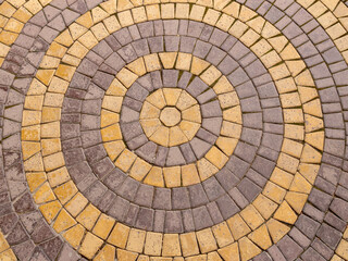 Fototapeta premium Background mosaic texture. The paving slabs are laid in the form of yellow and purple circles.