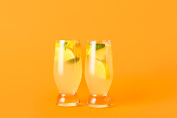 Glasses of tasty cold lemonade with mint on color background