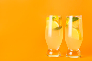 Glasses of tasty cold lemonade with mint on color background