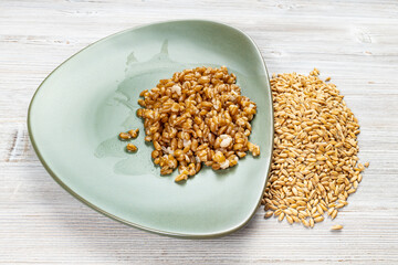 whole spelt grains and boiled porridge on plate