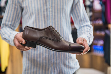 man holding shoes in shop