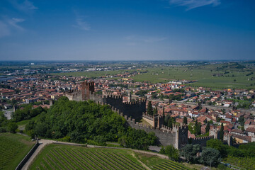 Soave castle aerial view, province of Verona, Italy. The delightful medieval town of Soave rises at the foot of the Lessinia Mountains. Aerial panorama of Italy castles.