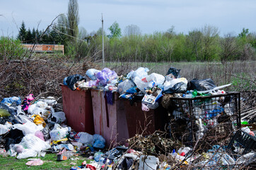 Contamination of nature with human waste. Garbage containers with trash. Overflowing trash cans...