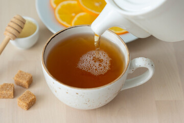 Green tea is poured into a cup.