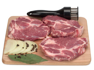 Three raw pork neck meat cuts with black pepper, onion, and bay leaves on a wooden board