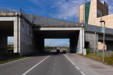 Fototapeta na wymiar Italian state highway under bridge of the Emilia Romagna high-speed train