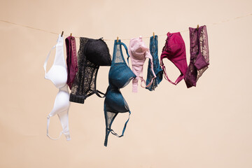 Various bra hanging on the rope background. Fitting room. Lingerie sale. - obrazy, fototapety, plakaty