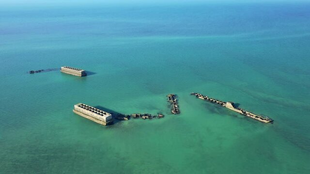 Deux &eacute;l&eacute;ments flottant et des structures d&eacute;grad&eacute;es du port artificiel am&eacute;ricain sur la plage de sable de Gold Beach &agrave; proximit&eacute; de Asnelles et Arromanches les bains d&eacute;truit par une temp&ecirc;te au bord de 