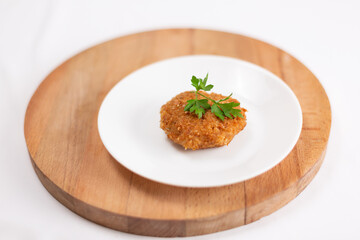 Pork cutlet garnished with parsley on a white plate