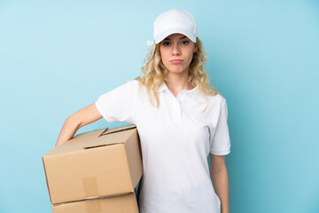 Young delivery woman isolated on blue background sad