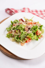 Caesar salad with shrimps on a white plate