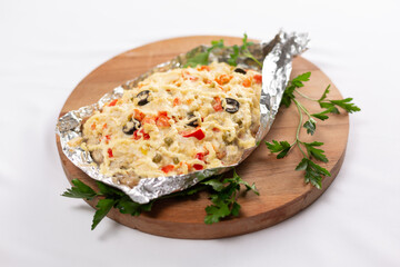 Closeup view of fried in foil sea fish and potato with paprica and cheese