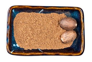 whole nutmeg seeds and powder in bowl cutout