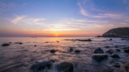 Beautiful Sunrise at Beach with Slow shutter speed on water with sun visible. Costal Area.