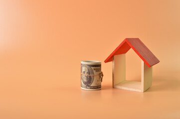 Obraz na płótnie Canvas Toy house and money banknote isolated on orange background