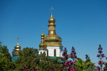 Fototapeta na wymiar Golden domes of the Holy Cross Church in the Kiev-Pechersk Lavra