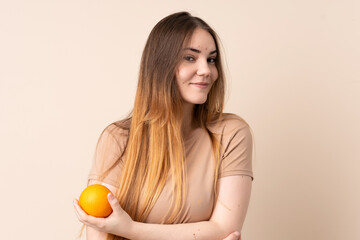 Young caucasian woman holding an orange