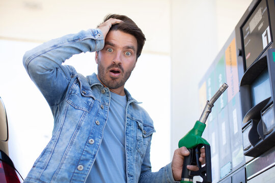 emotional businessman counting money with gasoline refueling car