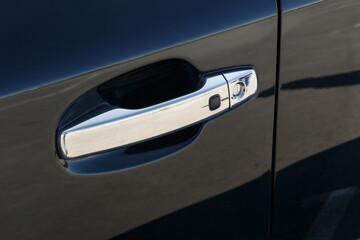 The chrome-plated door handle of a modern black car. Close-up car detail. Car Keyless entry system. Modern security systems - obrazy, fototapety, plakaty