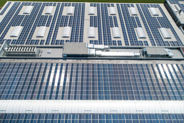 great field of solar panels and air conditionsystem on the roof of a industrial building