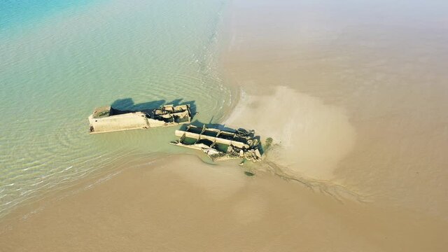 Une vue a&eacute;rienne de deux &eacute;l&eacute;ments du port artificiel am&eacute;ricain sur la plage de sable de Gold Beach &agrave; proximit&eacute; de Asnelles et Arromanches les bains d&eacute;truit par une temp&ecirc;te au bord de la mer de la Manc