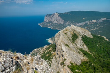 Mediterranean landscape. Forested rocks of the Black Sea coast of the southern coast of the Crimean Peninsula on a clear sunny day.