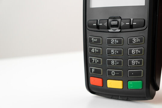 POS terminal or credit card reader machine on the white table with copy space. 