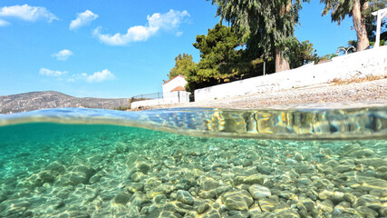 Underwater split photo of picturesque white washed chapel built by the sea in Greek island bay