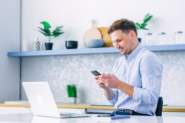 Professional male holding modern smart phone, typing, scrolling
