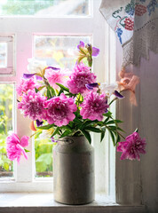 Old window and a bouquet of pink peonies